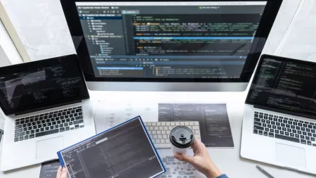 ABAP consultant working on three laptops