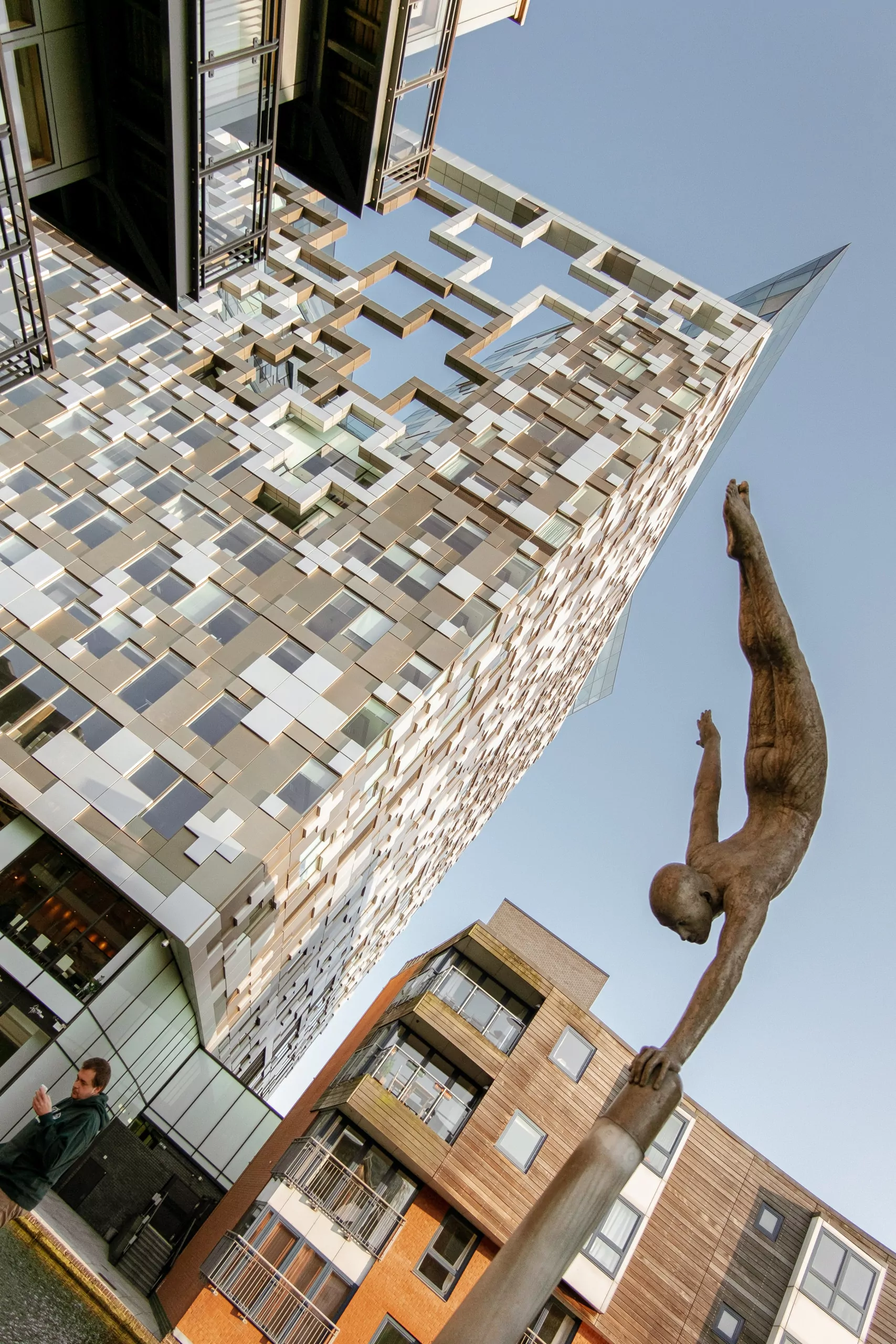 skyscraper and statue of a man standing on one hand